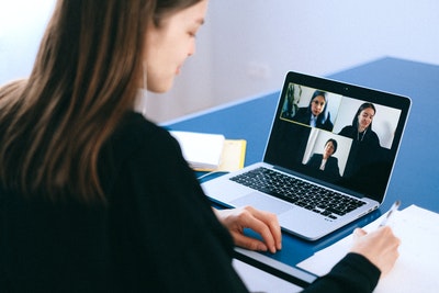 woman attending virtual Zoom meeting on laptop