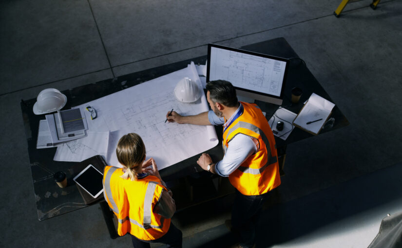 High-angle shot of construction designer and construction consultant going over a blueprint together in an industrial place of work